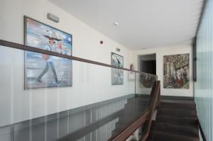 a staircase in a house with paintings on the walls at Hostal Emeritae in Mérida
