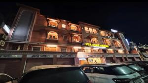 a building with cars parked in front of it at Virasat Mahal Heritage Hotel in Jaipur