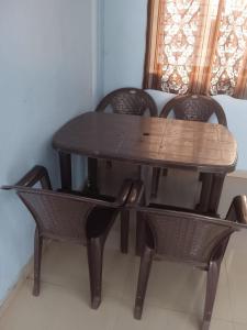 una mesa de madera con 2 sillas y una mesa y sillas de madera. en Hotel Silver, en Surat