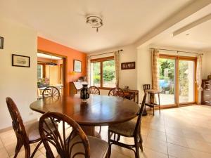 uma sala de jantar com uma mesa de madeira e cadeiras em LA KERVAO - Villa 5 chambres - Jardin - Terrasse - Internet em Quimper