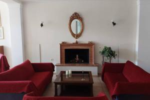a living room with two red couches and a fireplace at Villa Daphne in Tolo