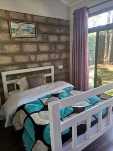 a white bed in a room with a window at Cozy Karen in Nairobi