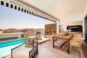 a patio with a table and chairs and a pool at The Weinberg Urban Pod in Windhoek