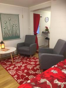 a living room with two chairs and a red rug at Aurora Center 3 in Rovaniemi