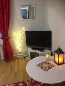 a living room with a white table and a television at Aurora Center 3 in Rovaniemi