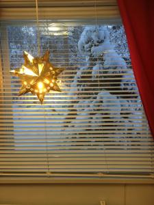 a christmas star hanging from a window with snow at Aurora Center 3 in Rovaniemi