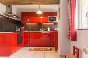cocina roja con armarios rojos y ventana en Appaloosa, en Lormes