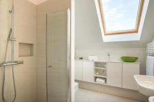 La salle de bains est pourvue d'une douche et d'un lavabo. dans l'établissement Ostsee - Appartement Nr 91 "Panta Rhei" im Strand Resort, à Heiligenhafen