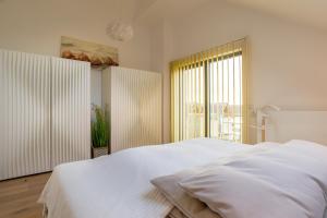 - une chambre blanche avec un grand lit et une fenêtre dans l'établissement Ostsee - Appartement Nr 91 "Panta Rhei" im Strand Resort, à Heiligenhafen