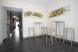 a room with three stools and paintings on the wall at Hostal Emeritae in Mérida