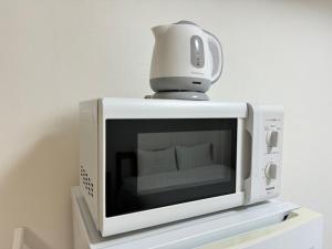 a microwave with a coffee maker on top of it at A&C STAY Shin-Osaka Higashikuchi 83 in Osaka