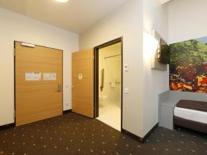 Cette chambre dispose d'une porte menant à une salle de bains. dans l'établissement B&B Hotel Berlin-Tiergarten, à Berlin