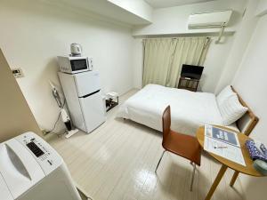 a small hotel room with a bed and a microwave at A&C STAY Shin-Osaka Higashikuchi 83 in Osaka