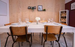 una mesa blanca con sillas y copas de vino en Le Grandiose - Gare - Parking - 6 personnes - Rêve au Mans, en Le Mans