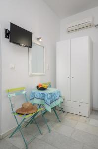 una camera con tavolo, due sedie e una TV di Depis apartments & suites a Naxos Chora