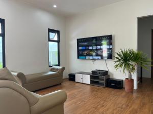 sala de estar con sofá y TV de pantalla plana en The Moongate, en San Fernando