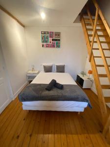 1 dormitorio con 1 cama y suelo de madera en L'Ecolière - Villa Piscine Chauffée - Rêve au Mans, en Teillé