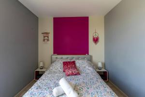 um quarto com uma cama com uma parede roxa em Le Char'Mans - Centre-ville - 4 pers - Rêve Au Mans em Le Mans