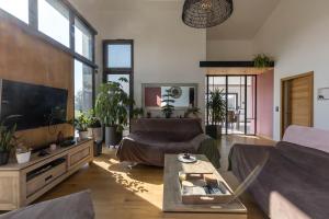 a living room with a couch and a tv at Le Yucca Spa -Campagne-Jacuzzi- 8p - Rêve au Mans in La Grenouillère