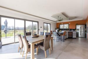 eine Küche und ein Esszimmer mit einem Tisch und Stühlen in der Unterkunft Le Yucca Spa -Campagne-Jacuzzi- 8p - Rêve au Mans 