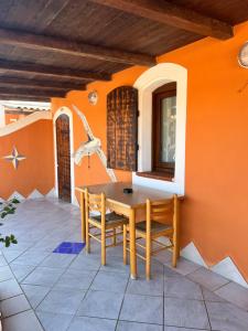 una sala da pranzo con pareti arancioni e tavolo e sedie di Residence La Conchiglia a Lampedusa