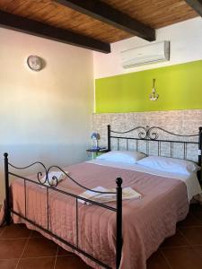 een bed in een kamer met een groene muur bij Residence La Conchiglia in Lampedusa