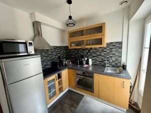 a kitchen with a white refrigerator and a sink at Terracotta - 5 pers - hyper centre - Rêve au Mans in Le Mans