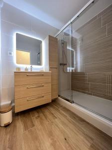 een badkamer met een douche, een wastafel en een spiegel bij The 70's - 8p - Balcon - Centre ville-Rêve au Mans in Le Mans