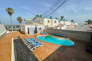 a patio with chairs and a swimming pool at Beachfront Villa San Antonio with Private Heated Pool BBQ in the Heart of Corralejo by Amazzzing Travel in Corralejo