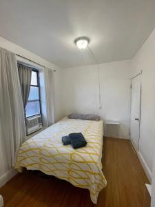 a bedroom with a bed with a yellow blanket at Room in a 2 Bedrooms apt. 10 minutes to Time Square! in West New York