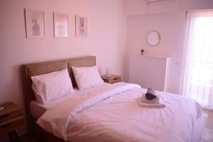 un dormitorio con una cama blanca con sombrero en Antonia's city apartment en Ioánina