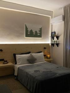 una camera da letto con un letto con un dipinto verde sul muro di Tiny Square a Nafpaktos