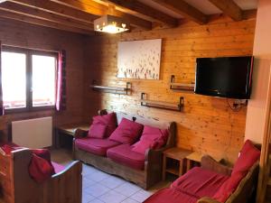 a living room with a couch and a flat screen tv at Chalet Flocon in Les Deux Alpes