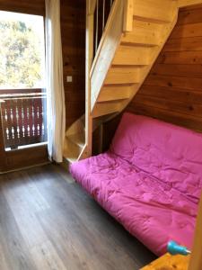 - un lit rose dans une chambre avec un escalier dans l'établissement Chalet Flocon, à Les Deux Alpes