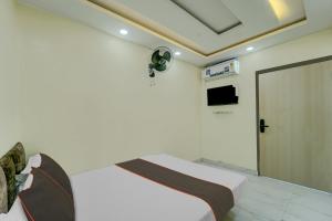 a white room with a bed and a door at Collection O Hotel Park City in Patna