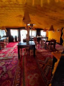 a living room with a table and chairs in a room at Honeymoon Luxury Glamping in Hassilabied