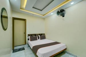1 dormitorio con 1 cama y techo con ventilador en Collection O Hotel Park City, en Patna