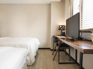 a bedroom with a desk with a television on it at CHECK inn Express Taipei Station in Taipei