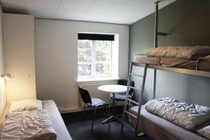 a room with bunk beds and a table and a window at Danhostel Haderslev in Haderslev