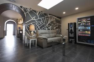 a living room with a couch and a tv at Hostal Emeritae in Mérida