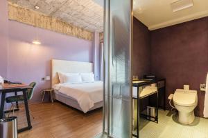 Habitación de hotel con cama y aseo en CHECK inn HIVE en Luodong