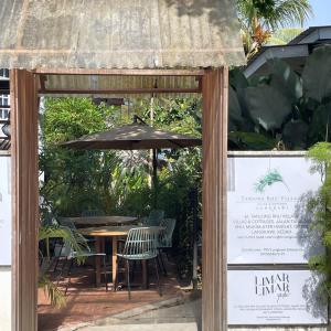 eine Terrasse mit einem Tisch und einem Sonnenschirm in der Unterkunft Kutum's Wooden House - Private Pool, Breakfast & Cafe in Huma
