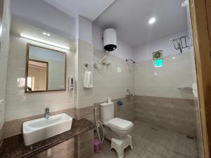 uma casa de banho com um WC, um lavatório e um espelho. em Max Guest House em Agra