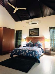 a bedroom with a bed and a ceiling fan at The Road's End in Gonikoppal