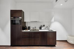 a kitchen with white cabinets and a brown refrigerator at limehome Vienna Roßauer Lände in Vienna