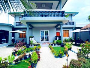Casa con balcón y patio con plantas. en Ekefaru Inn, en Viligili