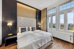 a bedroom with a large bed and large windows at limehome Vienna Roßauer Lände in Vienna