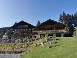 a large house on top of a hill at Hôtel du Lac des Confins in La Clusaz
