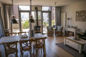 a living room with a dining room table and chairs at Ostsee - Reetdachhaus Nr 44 "Reethüs - Marina" im Strand Resort in Heiligenhafen