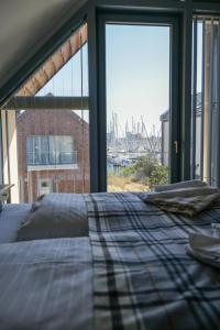 a bed in a room with a large window at Ostsee - Reetdachhaus Nr 44 "Reethüs - Marina" im Strand Resort in Heiligenhafen